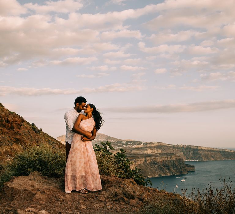 Bride looks back at groom as he wraps his arms around her on their honeymoon