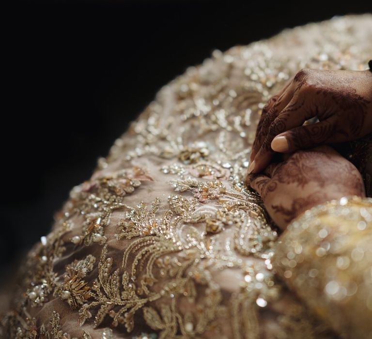 Bengali bride resting her hands in her lap with henna artwork 