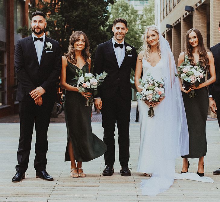 Sophisticated wedding party portrait with bridesmaids in forest green dresses