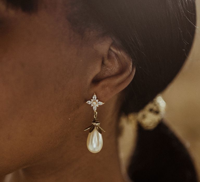 A close up shot of pearl drop earrings. 