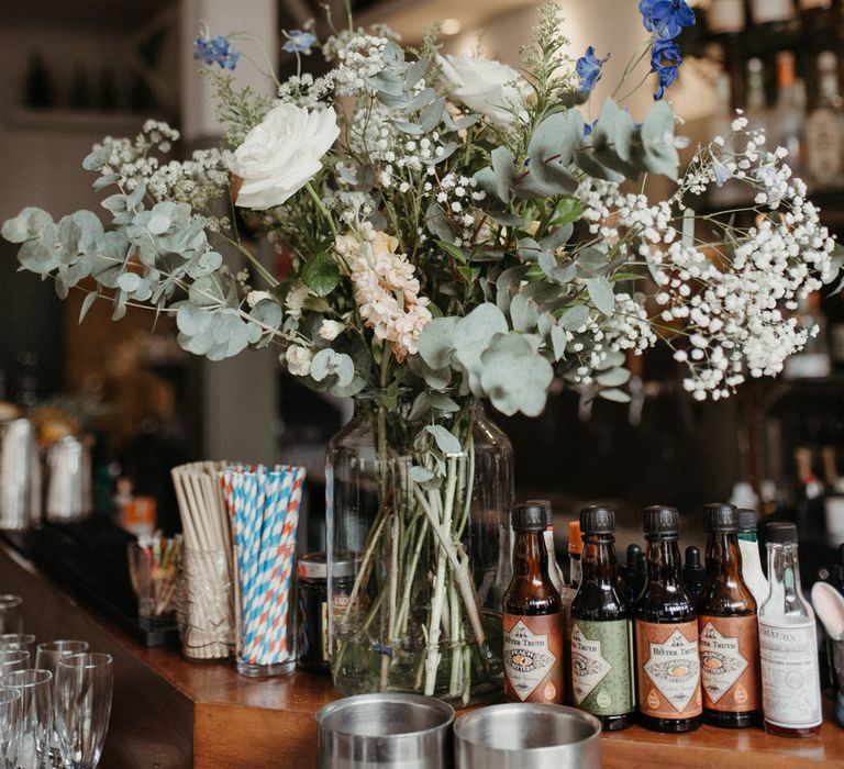 Bouquet of white roses, eucalyptus and wild flowers on a pub bar