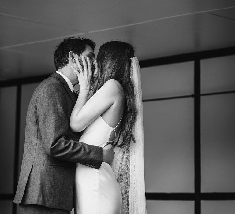 Black and white portrait of the bride and groom kissing at their civil wedding ceremony 