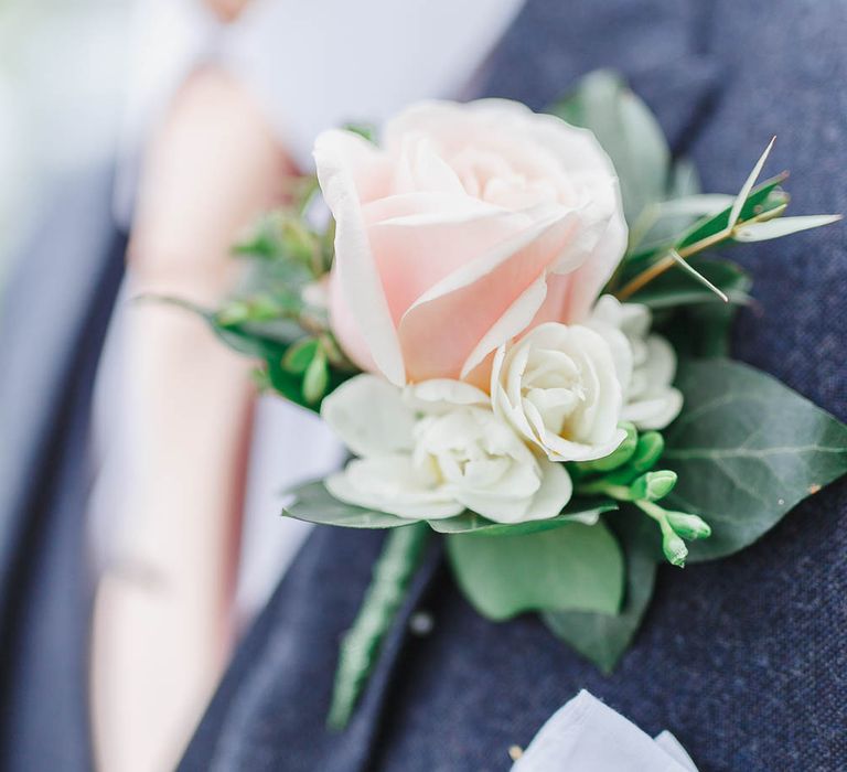 Groom in a grey suit with pink tie and pale pink rose buttonhole flower 