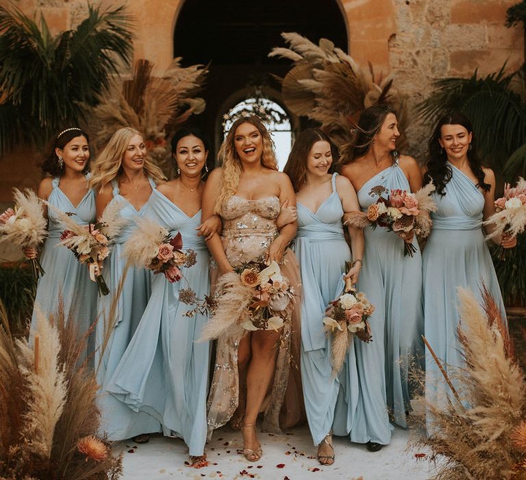 Bride stands with her bridesmaids as she wears ethereal style gown and star crown