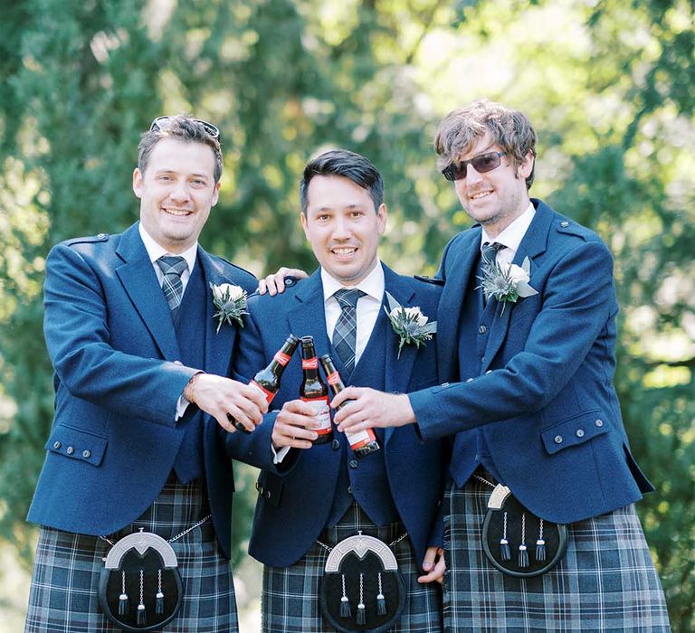 Groomsmen in blue tartan kilts, sporrans and wool blazers for classic Scottish wedding 