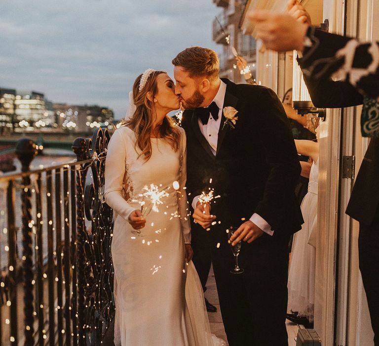 Black-tie wedding sparkler moment on a balcony with the London skyline in the background