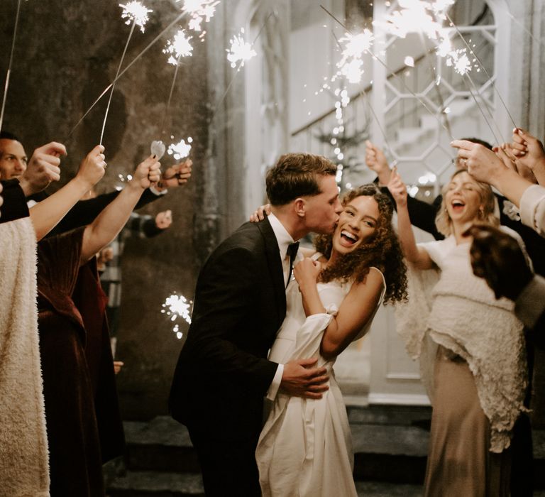 Bride & groom hug and kiss during sparkler exit