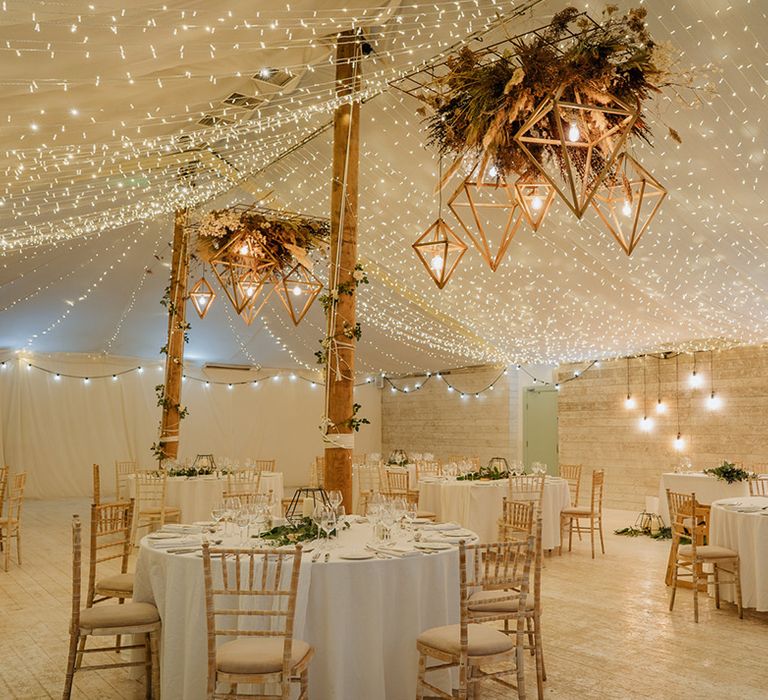 Dried flower installations with fairy light canopy at stunning wedding reception 