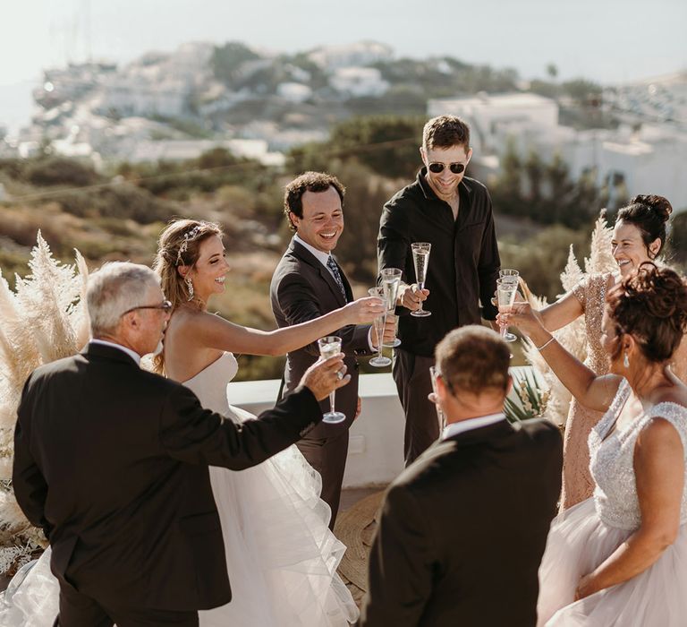 Bride & groom cheers on their wedding day outdoors in Greece 