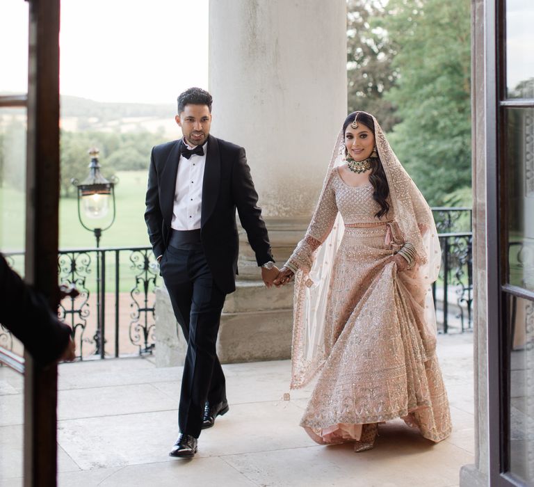 Bride & groom walk hand in hand with one another on their wedding day