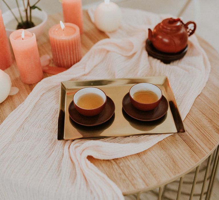 modern Chinese tea ceremony at asian wedding and peach pillar candles 