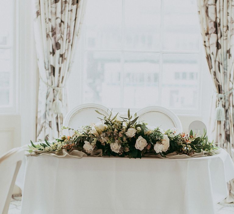 White sweetheart wedding table with faux wedding flowers 