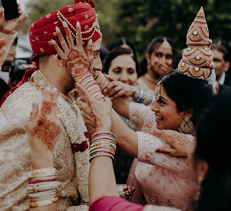 Wedding guests gather around groom during Hindu ceremony outdoors at Braxted Park Estate 