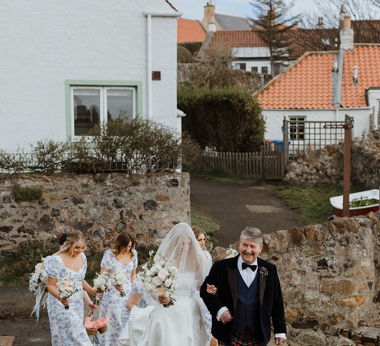 Bridal party and father of the bride walk with the bride to the wedding ceremony at St Monans Kirk