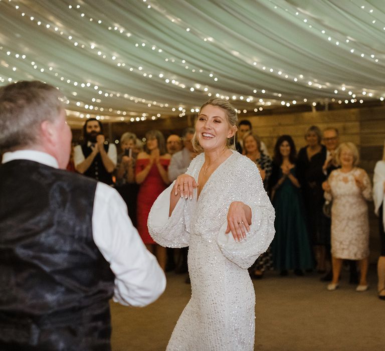 Bride in sparkly wedding reception dress dancing with her father for special father daughter dance 