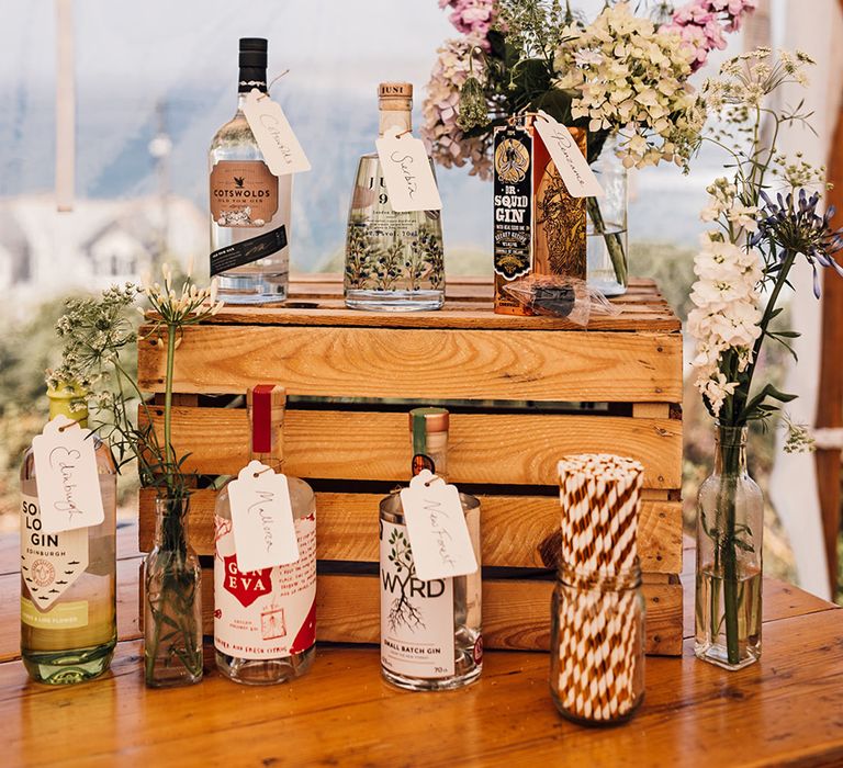 Gin cocktail bar with different bottles on gin on display on wooden crates