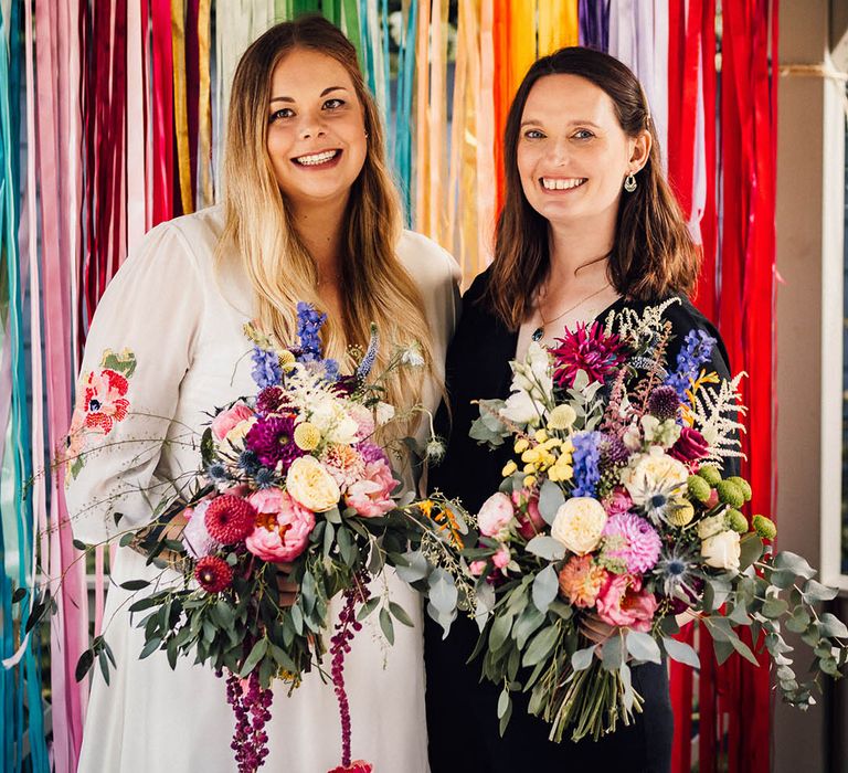 Rainbow wedding theme with colourful ribbon streamer decorations as photo backdrop at wedding 