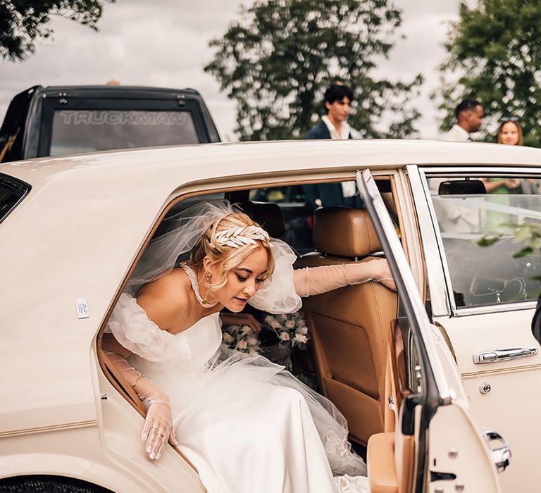 Bride wearing pink sparky bow Mach & Mach shoes getting out of white wedding car