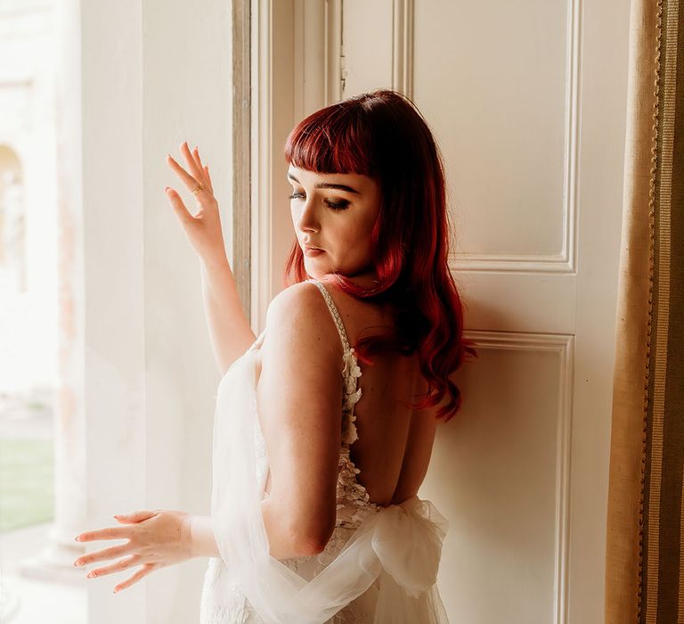 Bride wearing tulle off the shoulder wedding dress with red hair 