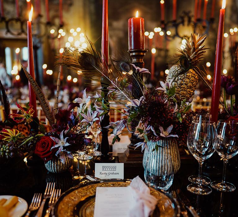 Red and black and gold wedding colour palette for gothic style wedding tablescape with peacock feathers 