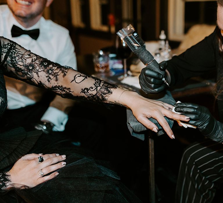  Bride gets her wedding band tattooed at the wedding reception by real tattoo artist 