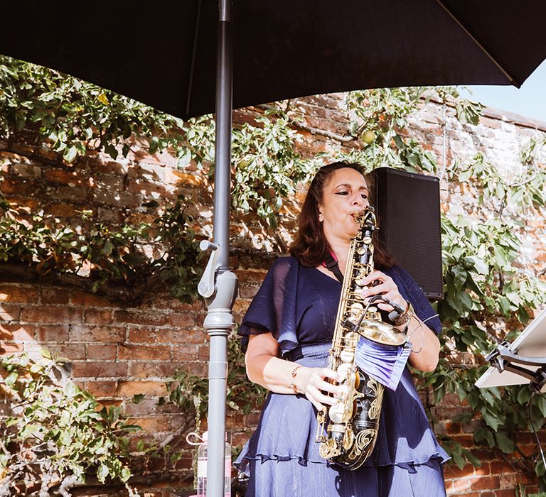 Saxophone player plays during the cocktail hour at wedding 