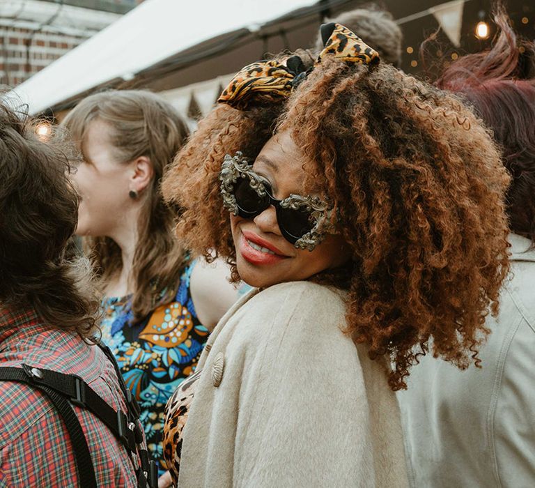 Wedding guest wearing funky sunglasses at contemporary town hall wedding 