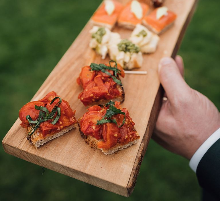 Wooden serving tray with wedding canapes for guests 