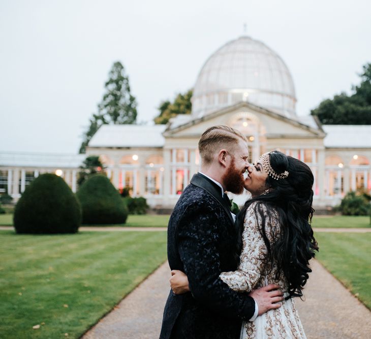 Bride and groom kissing in front of Syon Park wedding venue