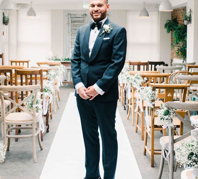 Groom in tuxedo standing in the ceremony room 