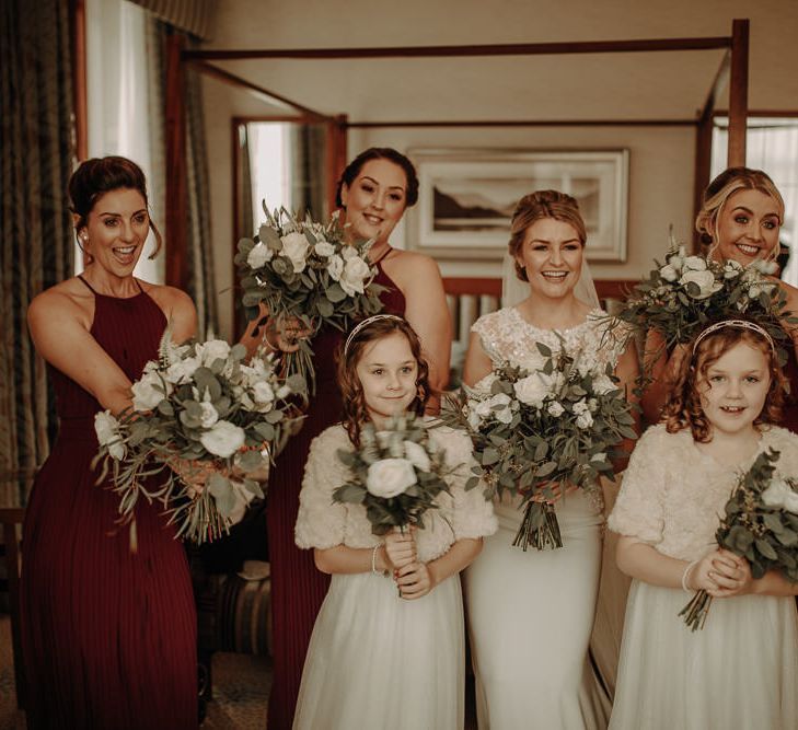 Bridal party at winter wedding with white theme and burgundy bridesmaid dresses