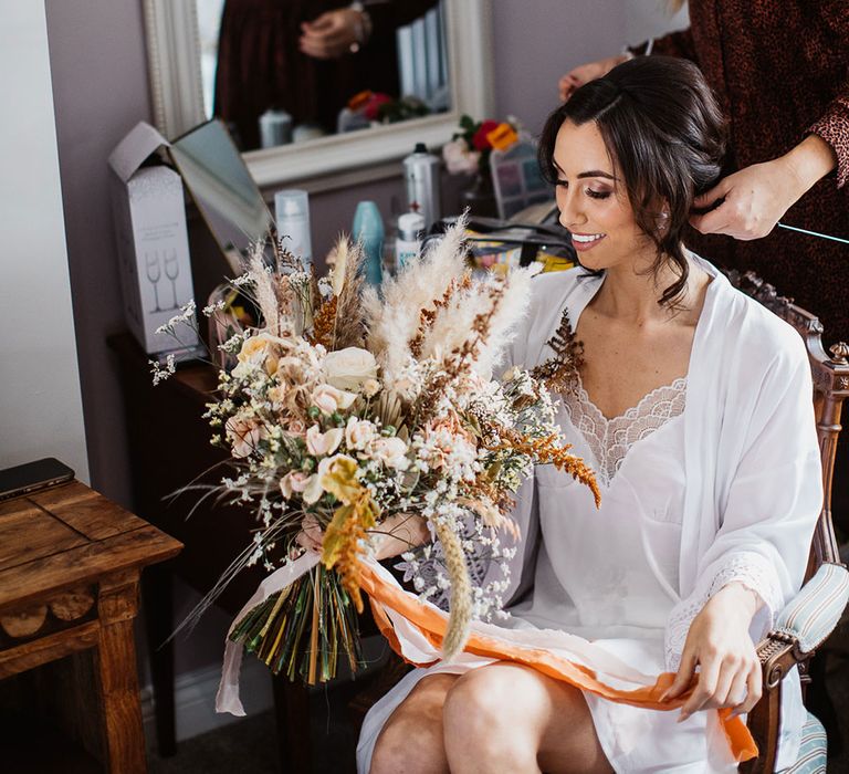 Bride getting ready with rose and pampas grass bouquet