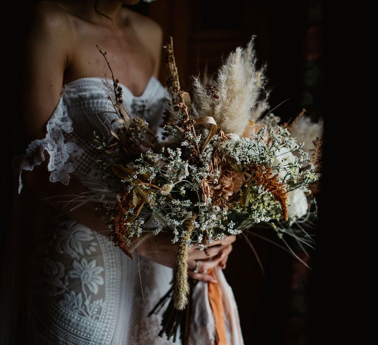 Bride holds pampas grass and gypsophila wedding bouquet