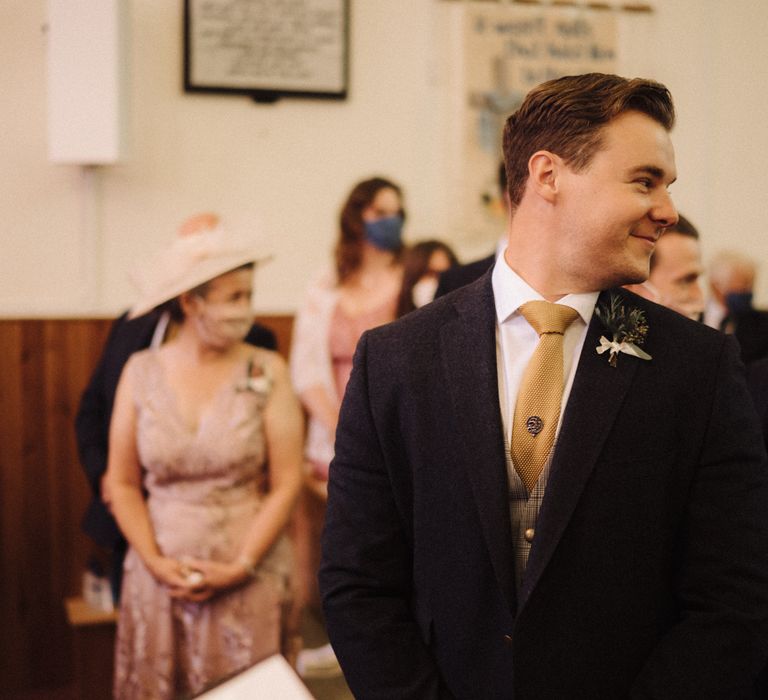 Groom waits at the alter for bride on wedding morning