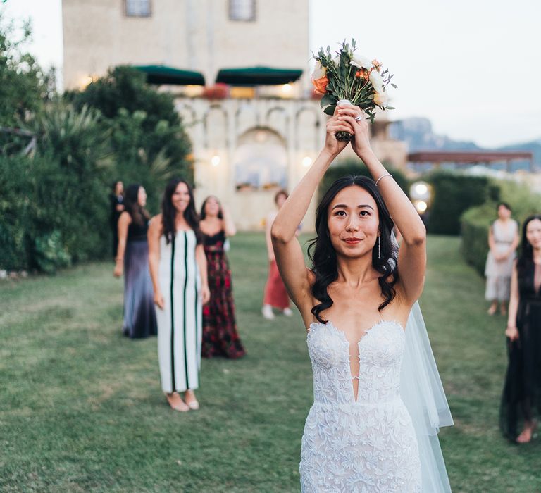 Bride in strapless wedding dress throwing her bouquet 