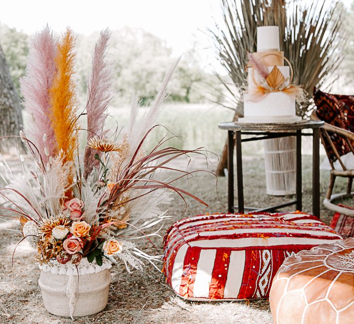 Moroccan themed furniture next to large dried floral arrangement outdoors