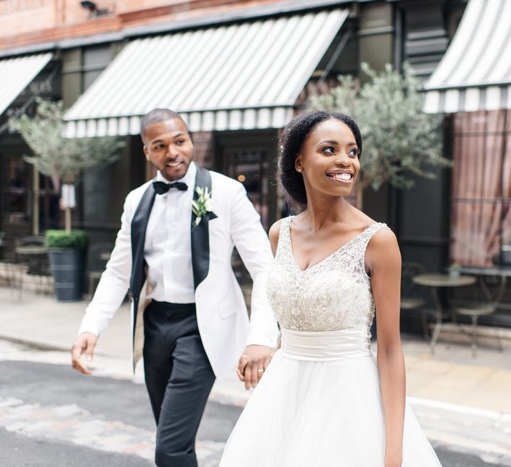 Bride leads groom holding his hand on the streets of London