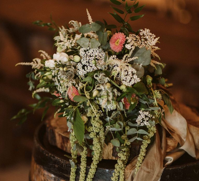 Floral bouquet featuring whites and pinks tied with neutral ribbon