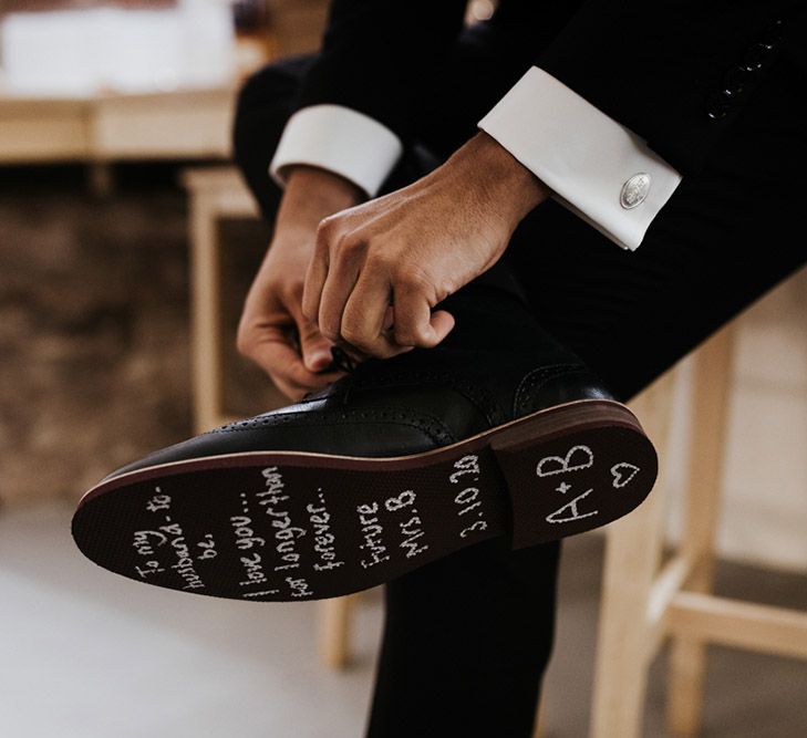 The sole of a grooms shoe reads 'to my husband to be, I love you for longer than forever... Future Mrs B'