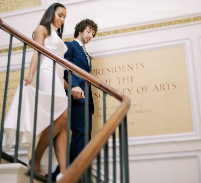 Bride & groom walk down staircase together