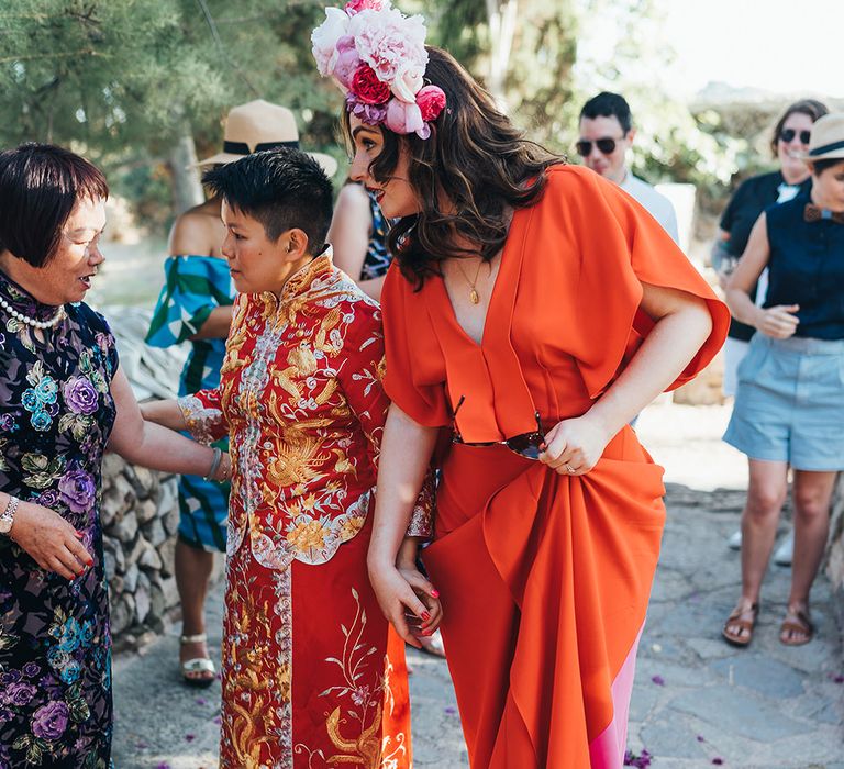 Brides walk together in traditional Chinese dress and red wedding gown