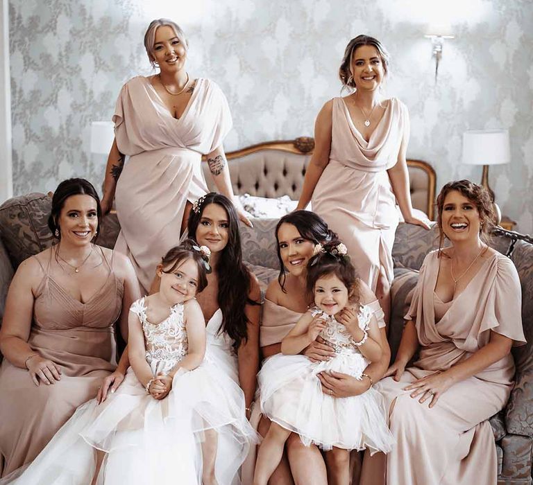 Bridal party wear nude pink long dresses & smile with flower girls in their white puffed sequin detailed dresses