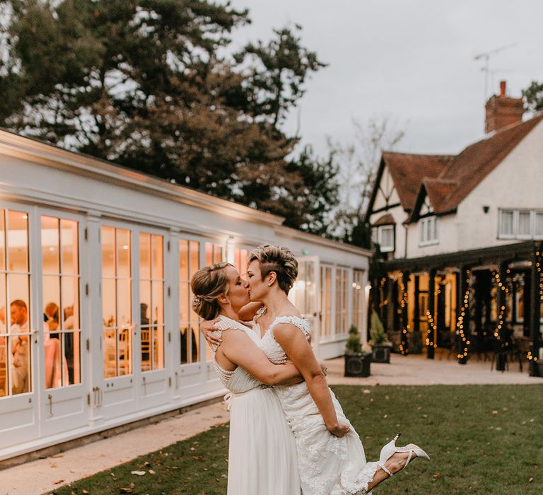 Brides embrace outdoors on their wedding day