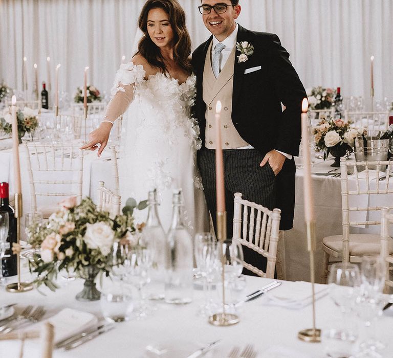 Bride and groom admire their wedding tables