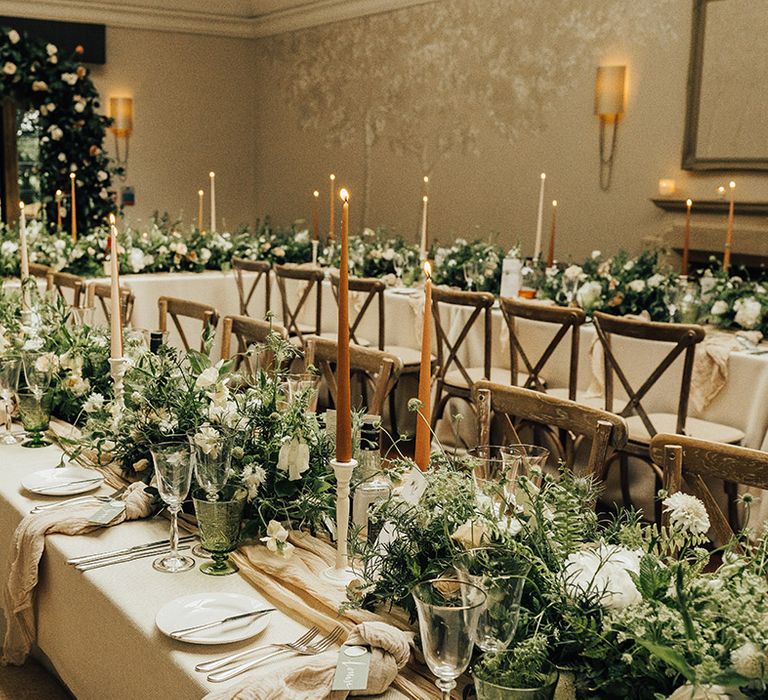 Elegant wedding reception flowers and decor at Foxhill Manor with taper candles and foliage flowers and floral arch 