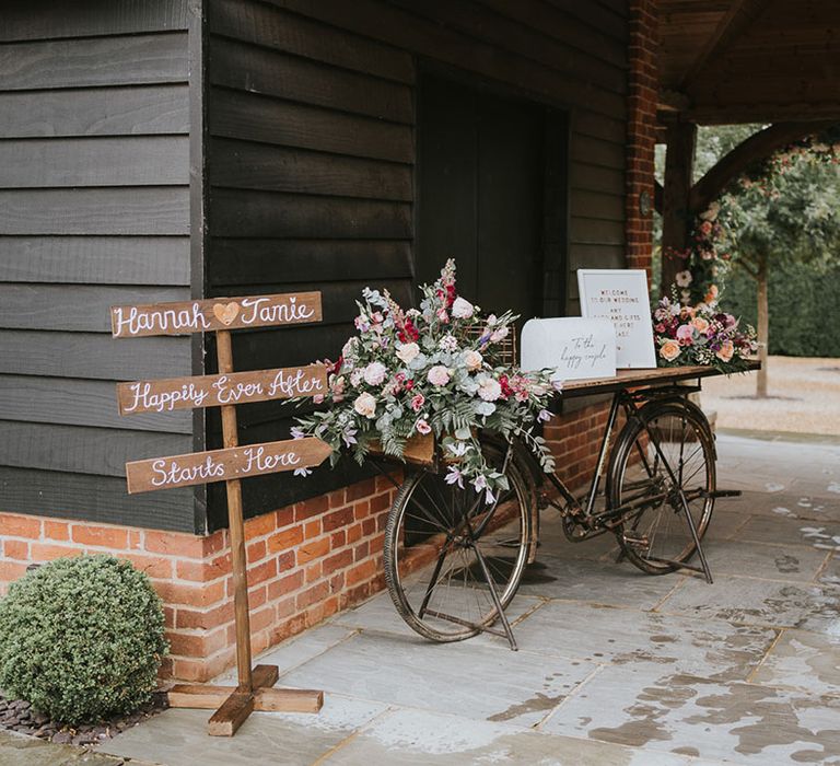 Handmade wooden sign with personalised details as well as an old bike with an area for the guest book 