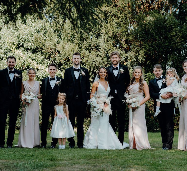 Wedding party portrait at black-tie wedding Elmore Court with pink bridesmaid dresses, mermaid wedding dress and the groomsmen in tuxedos 