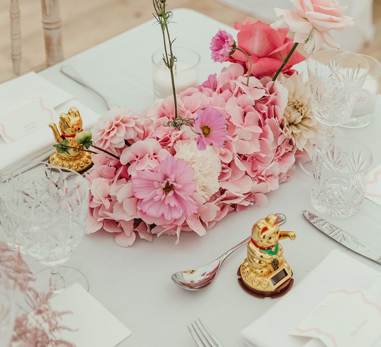 Pink flower arrangements for wedding table settings with maneki-neko decor or lucky Chinese waving cats