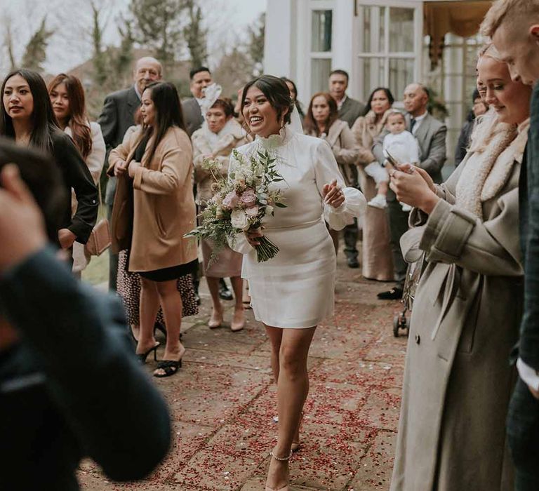 Bride in Vanessa Cocchiaro Paris short wedding dress, long white veil, with neutral flower bouquet 