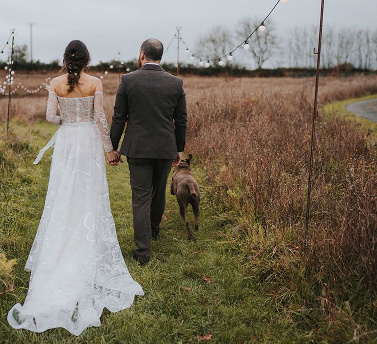 Bride and groom walk around their wedding venue a Ash Barton Estate